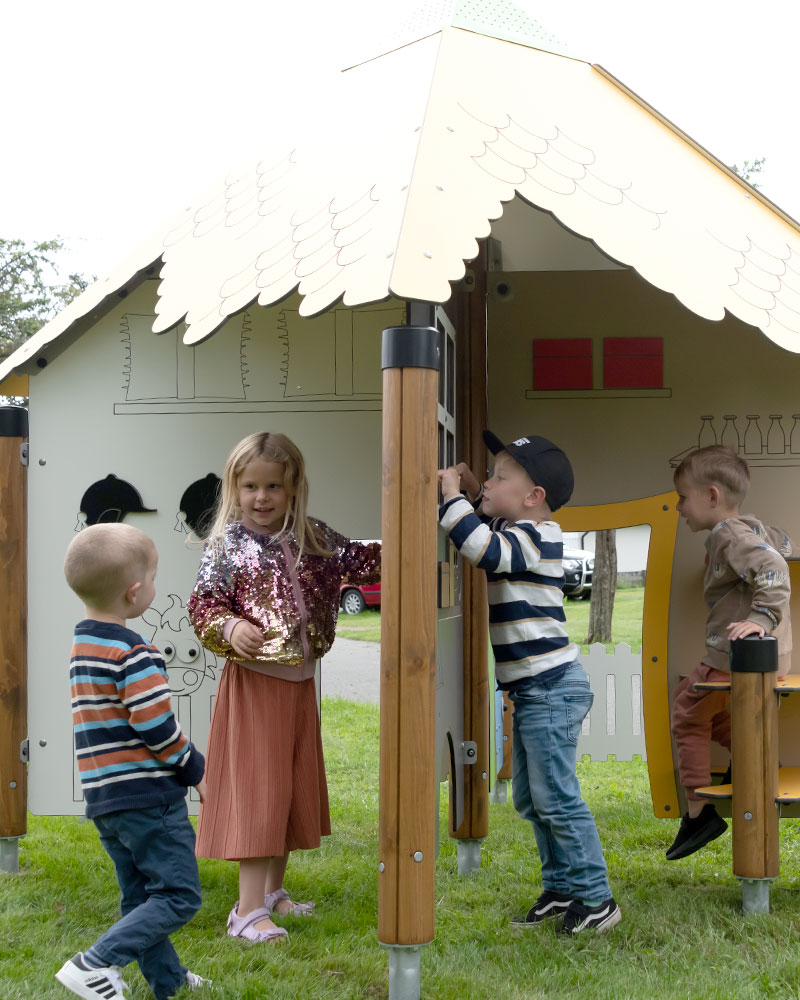 Eine Gruppe junger Kinder und Kleinkinder spielt auf einem Spielplatz mit dem Eddul Playhouse.